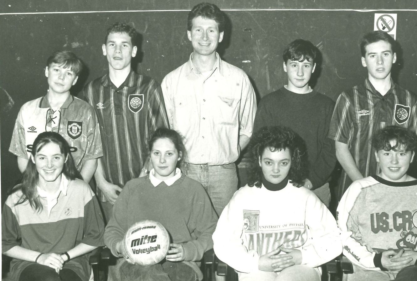 A volleyball team in football shirts, one holding the ball
