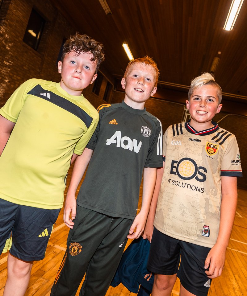 Three members in football kit in the PYC sports hall
